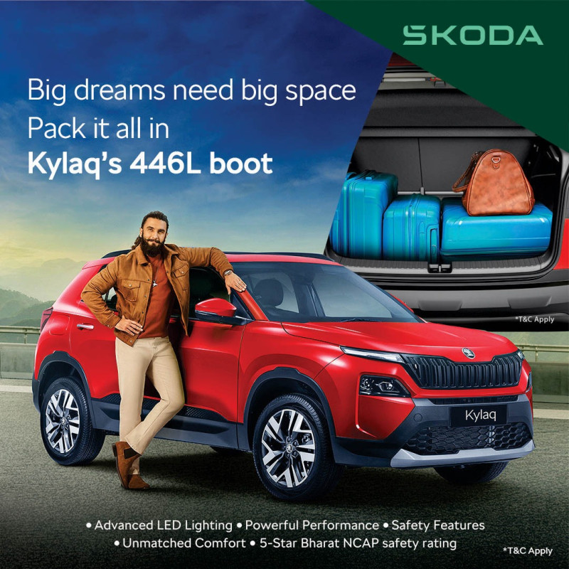 Man standing with red Skoda Kylaq SUV highlighting premium 446L boot space